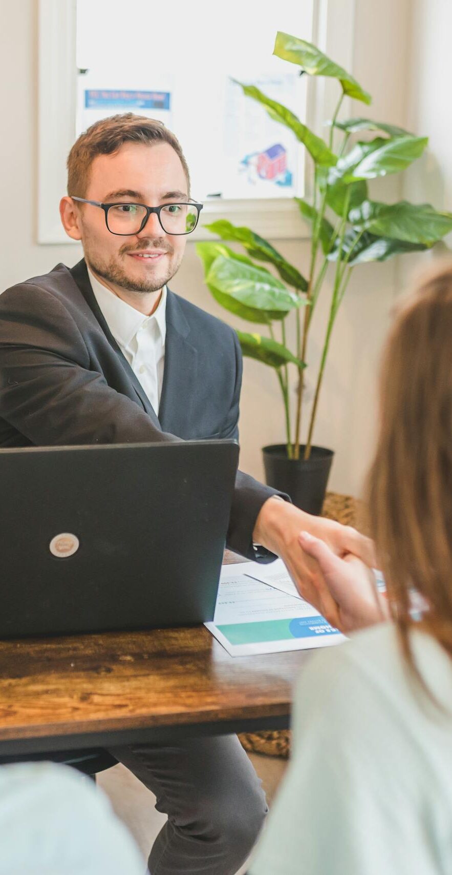 A mortgage broker meeting clients in an office, discussing agreements and loans.